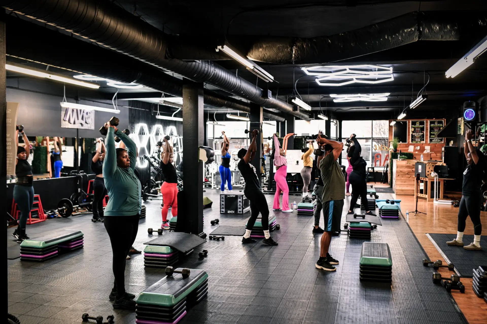 NuLife bootcamp members lifting weights together in the studio